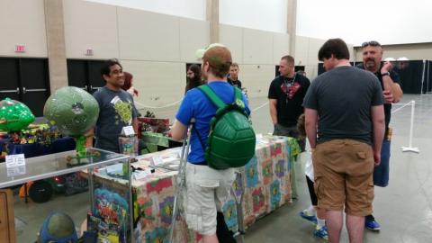 Fugitoid and Hit Girl working the Cowabunga Corner booth while fans ask questions and check out the collection.